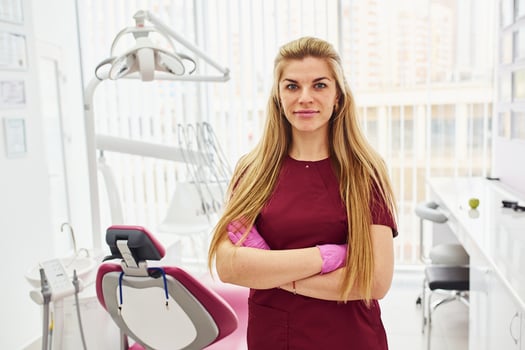 Young female dentist in uniform standing in stomatology office photo