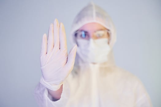 Stop the virus sign. Portrait of female doctor scientist in lab coat, defensive eyewear and mask photo