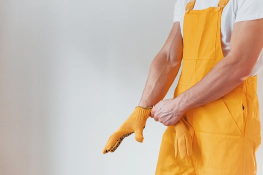 Handyman in yellow uniform preparing for work indoors. House renovation conception photo