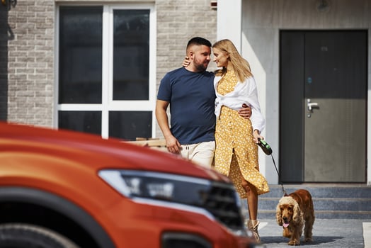 Lovely couple have a walk together with dog outdoors near the car photo