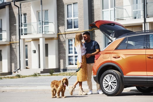Lovely couple have a walk together with dog outdoors near the car photo