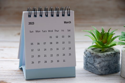 March 2023 white desk calendar on wooden table. New year concept. photo