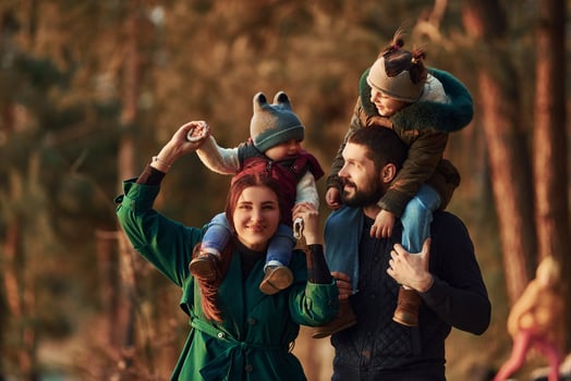 Mother and father with their little son have a walk in spring forest at daytime photo