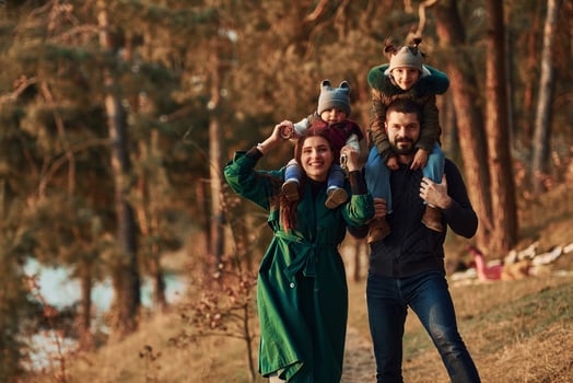 Mother and father with their little son have a walk in spring forest at daytime photo
