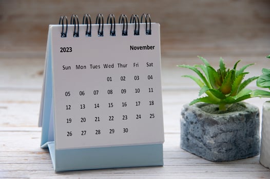 November 2023 white desk calendar on wooden table. Copy space photo