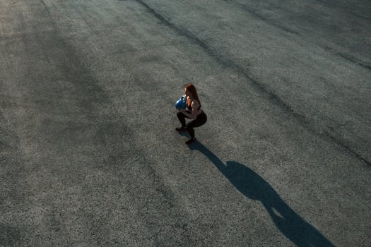 Lifting weight. Top view of woman that have fitness day on the road at evening photo