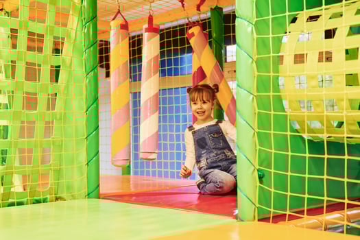Happy little girl in casual clothes have fun in children's game complex photo
