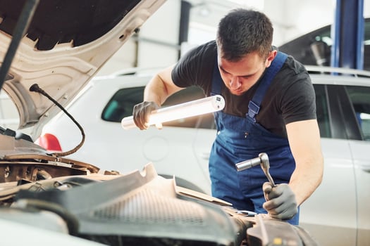 Auto mechanic working in garage. Repair service photo