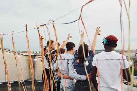 Decorated place. Cloudy weather. Group of young people in casual clothes have a party at rooftop together at daytime photo