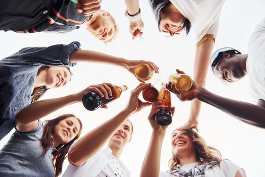 View from below. Doing cheers. Group of young people in casual clothes have a party at rooftop together at daytime photo