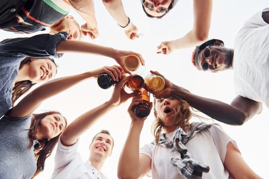 View from below. Doing cheers. Group of young people in casual clothes have a party at rooftop together at daytime photo