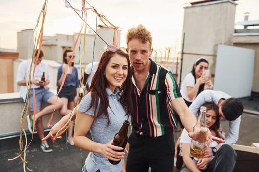 Happy couple. Group of young people in casual clothes have a party at rooftop together at daytime photo