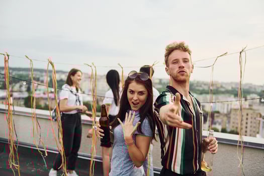 Happy couple. Group of young people in casual clothes have a party at rooftop together at daytime photo