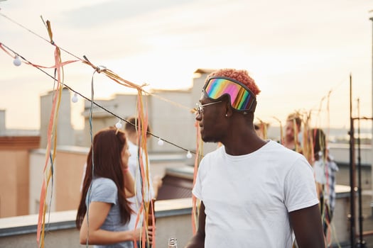 Posing for a camera. Group of young people in casual clothes have a party at rooftop together at daytime photo