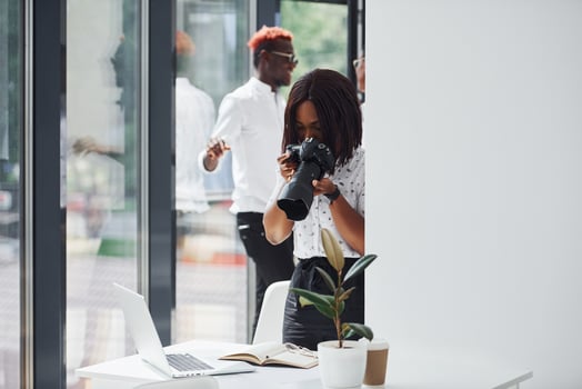 Woman testing camera. Group of african american business people working in office together photo