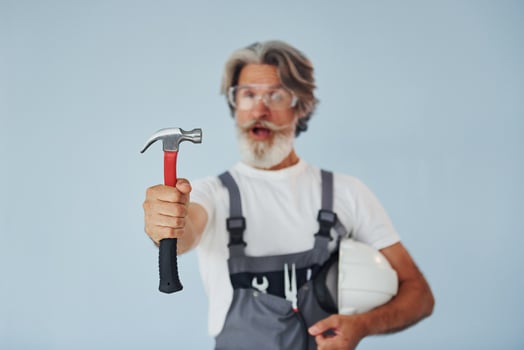 Repairman ready for work. Senior stylish modern man with grey hair and beard indoors photo