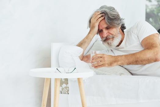 Conception of illness and virus. Senior stylish modern man with grey hair and beard indoors photo
