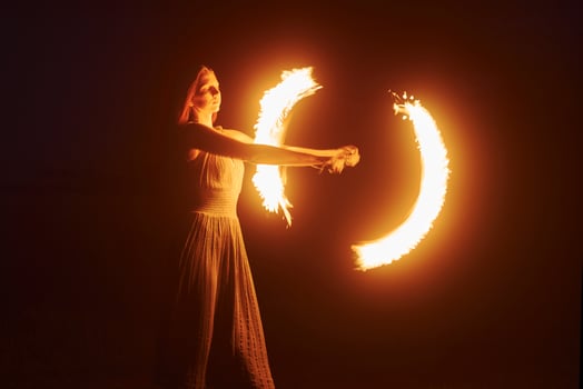 Woman doing a fire show at night outdoors photo