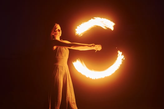 Photo with a long exposure. Fire show by woman in dress in night Carphatian mountains. Beautiful landscape Pro Photo