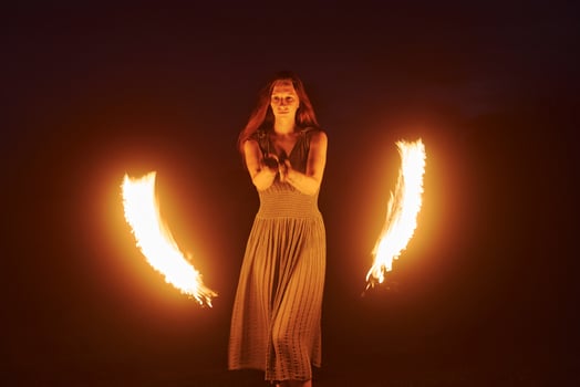 Photo with a long exposure. Fire show by woman in dress in night Carphatian mountains. Beautiful landscape Pro Photo