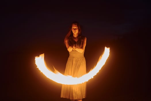 Photo with a long exposure. Fire show by woman in dress in night Carphatian mountains. Beautiful landscape Pro Photo