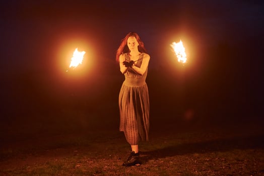 Photo with a long exposure. Fire show by woman in dress in night Carphatian mountains. Beautiful landscape Pro Photo