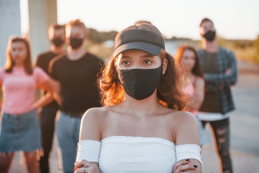 Beautiful girl in mask. Group of protesting young people that standing together. Activist for human rights or against government photo