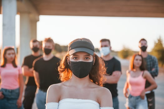 Beautiful girl in mask. Group of protesting young people that standing together. Activist for human rights or against government photo