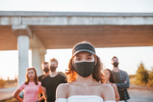 Beautiful girl in mask. Group of protesting young people that standing together. Activist for human rights or against government photo