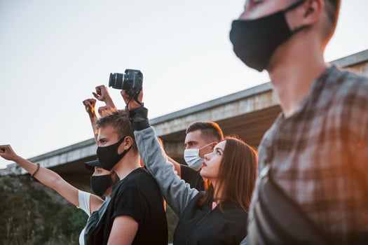 Photographer with camera. Group of protesting young people that standing together. Activist for human rights or against government photo