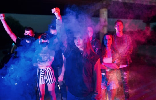 Smoke, fists, police. Group of protesting young people that standing together. Activist for human rights or against government photo