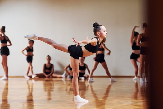 Group of female kids practicing athletic exercises together indoors photo