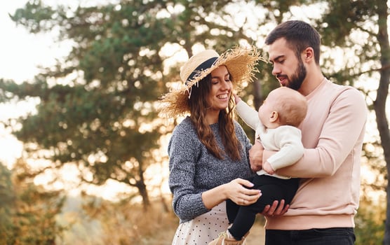 Unity of the people. Happy family of mother, family and little baby rests outdoors. Beautiful sunny autumn nature photo
