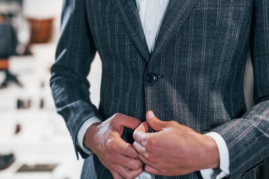 Close up view. Young guy in modern store with new clothes. Elegant expensive wear for men photo