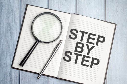 Text written in brown diary step by step and magnifier photo