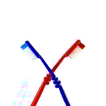 Two toothbrushes crossed on a white background. Blue and red toothbrushes photo