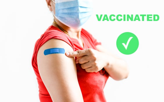 A blue plaster is attached to the woman's arm. Concept for first aid after coronavirus COVID-19 vaccination, and professional, medical, needle, blood, cancer. Closeup, white blurred background photo