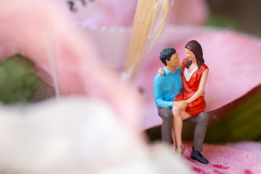Miniature people Young girl sitting on her boy lap photo