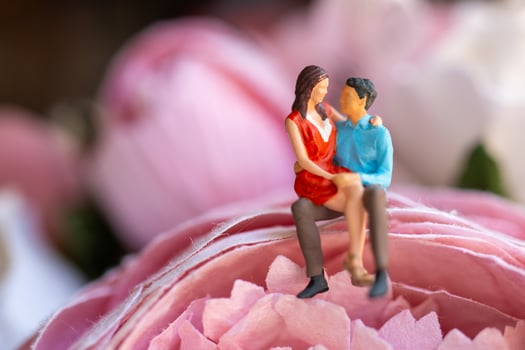 Miniature people Young girl sitting on her boy lap photo
