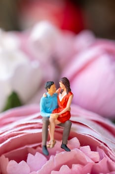 Miniature people Young girl sitting on her boy lap photo
