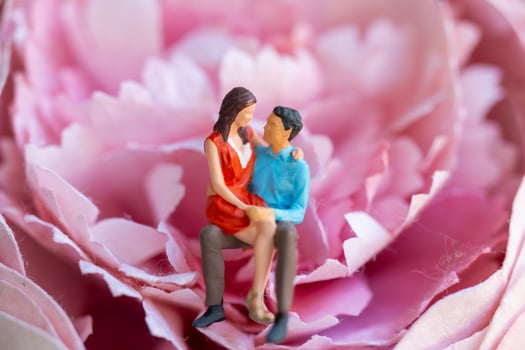 Miniature people Young girl sitting on her boy lap photo