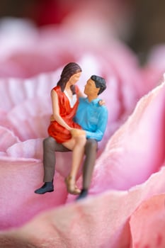 Miniature people Young girl sitting on her boy lap photo