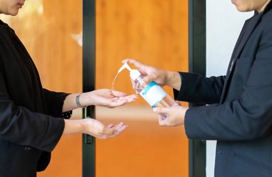 Two Asian business man and woman in black suit are washing their hands by alcohol gel before enter the meeting seminar room. photo