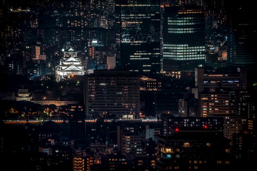 Osaka Castle illuminated at night in birdeye or top view with cityscape and high building around, Osaka Prefecture, Japan. photo