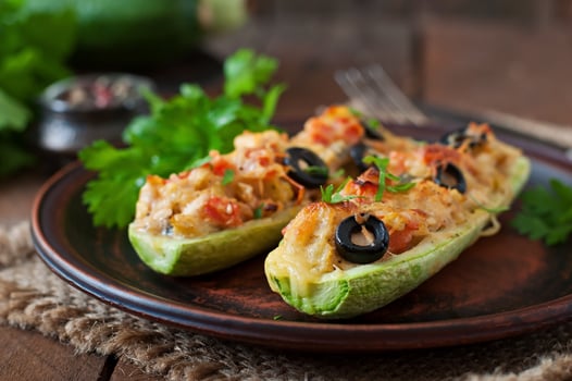 Stuffed zucchini with chicken, tomatoes and olives with cheese crust photo