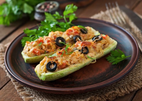 Stuffed zucchini with chicken, tomatoes and olives with cheese crust photo