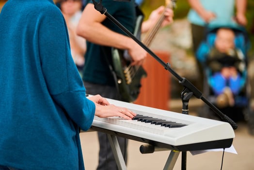 Musician woman playing on synthesizer keyboard piano, hands press synthesizer keys on concert stage photo