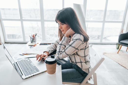 Doing paperwork. Young female freelance worker is indoors in home at daytime photo