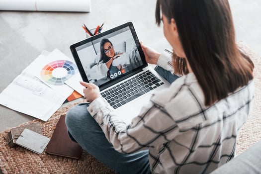 Have online conversation with other woman. Young female freelance worker is indoors in home at daytime photo