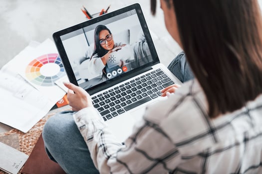 Have online conversation with other woman. Young female freelance worker is indoors in home at daytime photo
